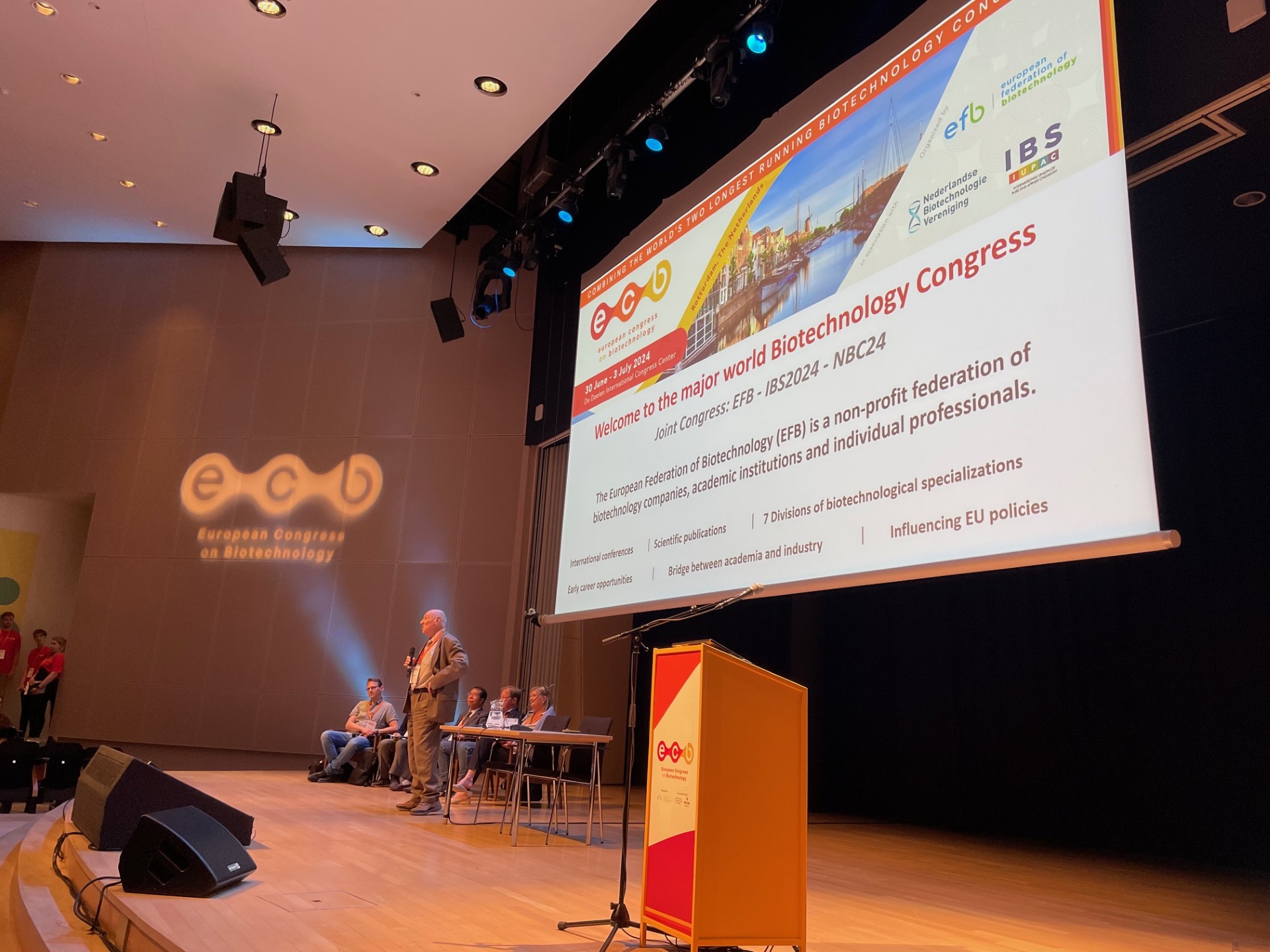 Jeff Cole presenting at European Congress on Biotechnology with large event screen